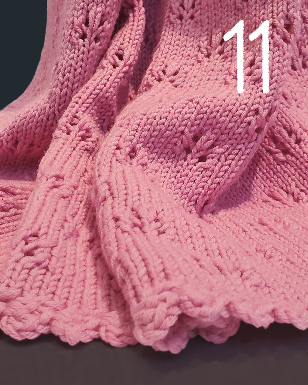 Rosafarbene, gestrickte Decke mit feinem Lochmuster und gehäkelten Kanten